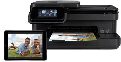 A printer outputting a photo, and in front of it is an iPad Air with its screen showing the printed photo